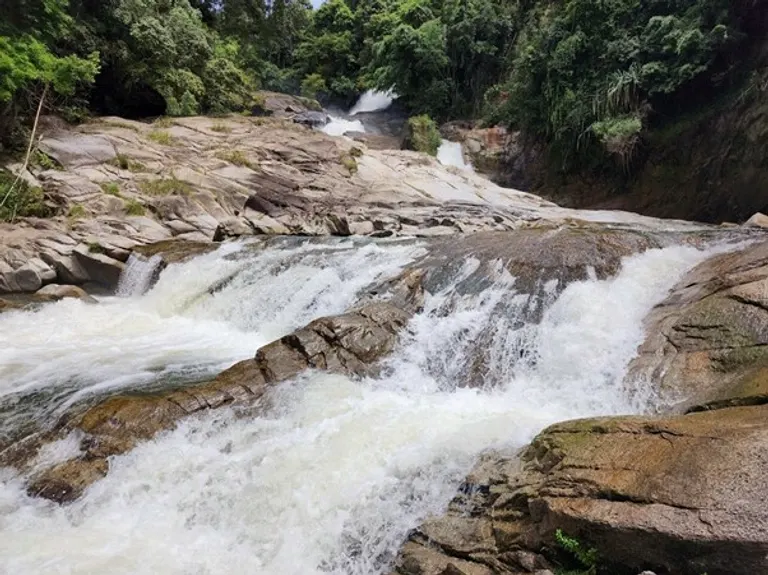 Chamang waterfall near Bentong: white water over broad granite ledges between rainforest banks.